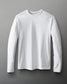 A white long-sleeve shirt is laid flat against a gray background, showcasing a simple and versatile design suitable for casual wear.