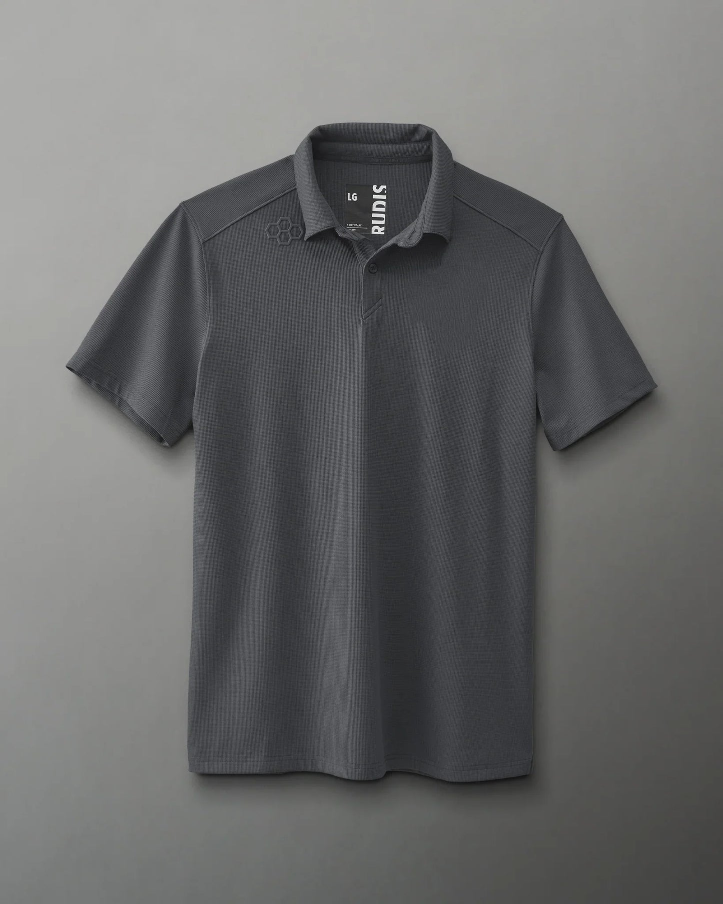 A dark gray polo shirt with a collared neckline and short sleeves, featuring a small logo on the left shoulder, suitable for casual and semi-formal wear against a soft gray background.