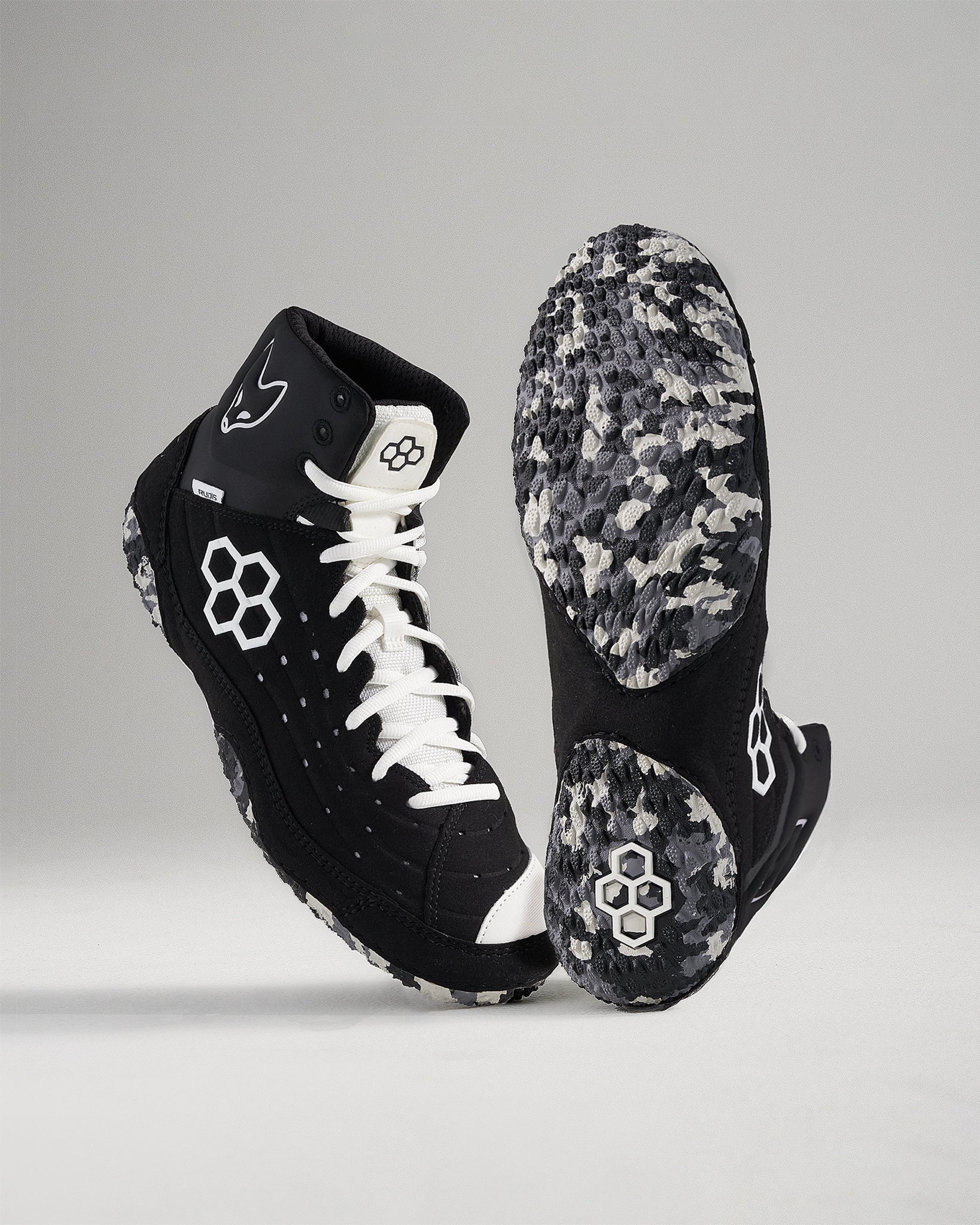 A pair of modern black and white sports shoes with a textured sole designed for traction and performance