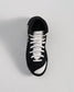 This image displays a black athletic shoe from a top view featuring white laces and a sleek design