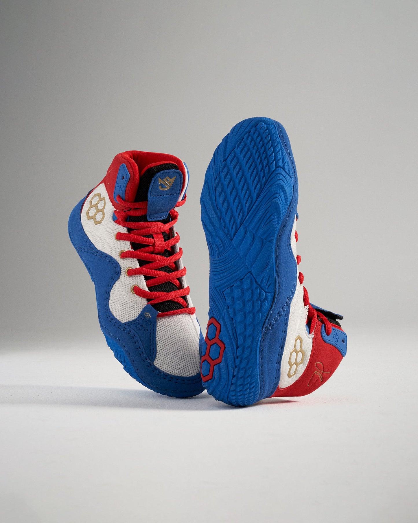 These high-top athletic shoes feature a vibrant red white and blue design with unique detailing and a textured sole for superior grip