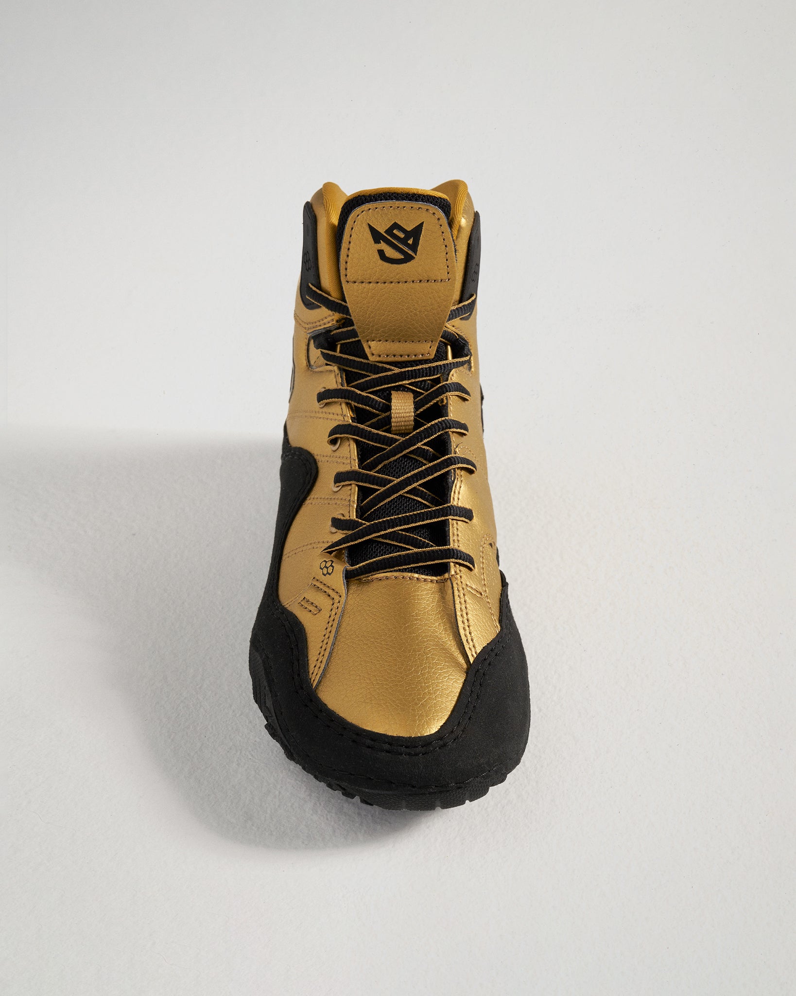 A stylish high-top sneaker in a striking gold and black color scheme featuring a robust design and a textured sole for traction