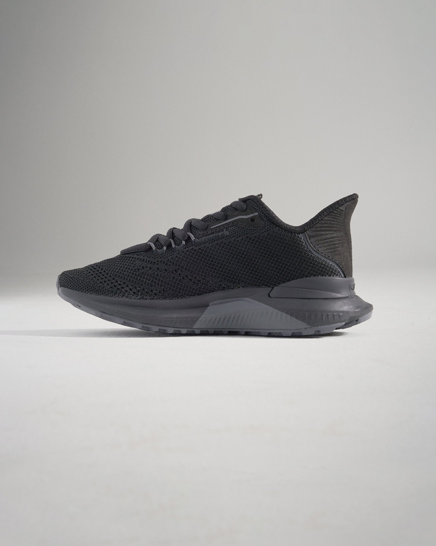 A sleek black running shoe featuring a breathable mesh upper and a durable textured sole designed for optimal performance and style