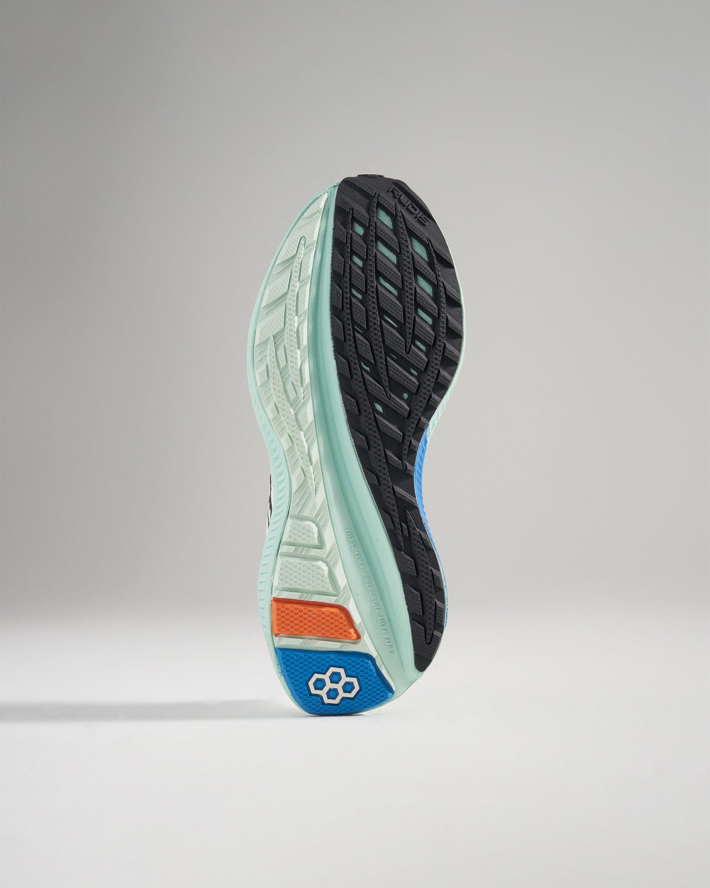 Detailed view of a running shoes sole featuring a mix of black and pastel green colors with vibrant accents