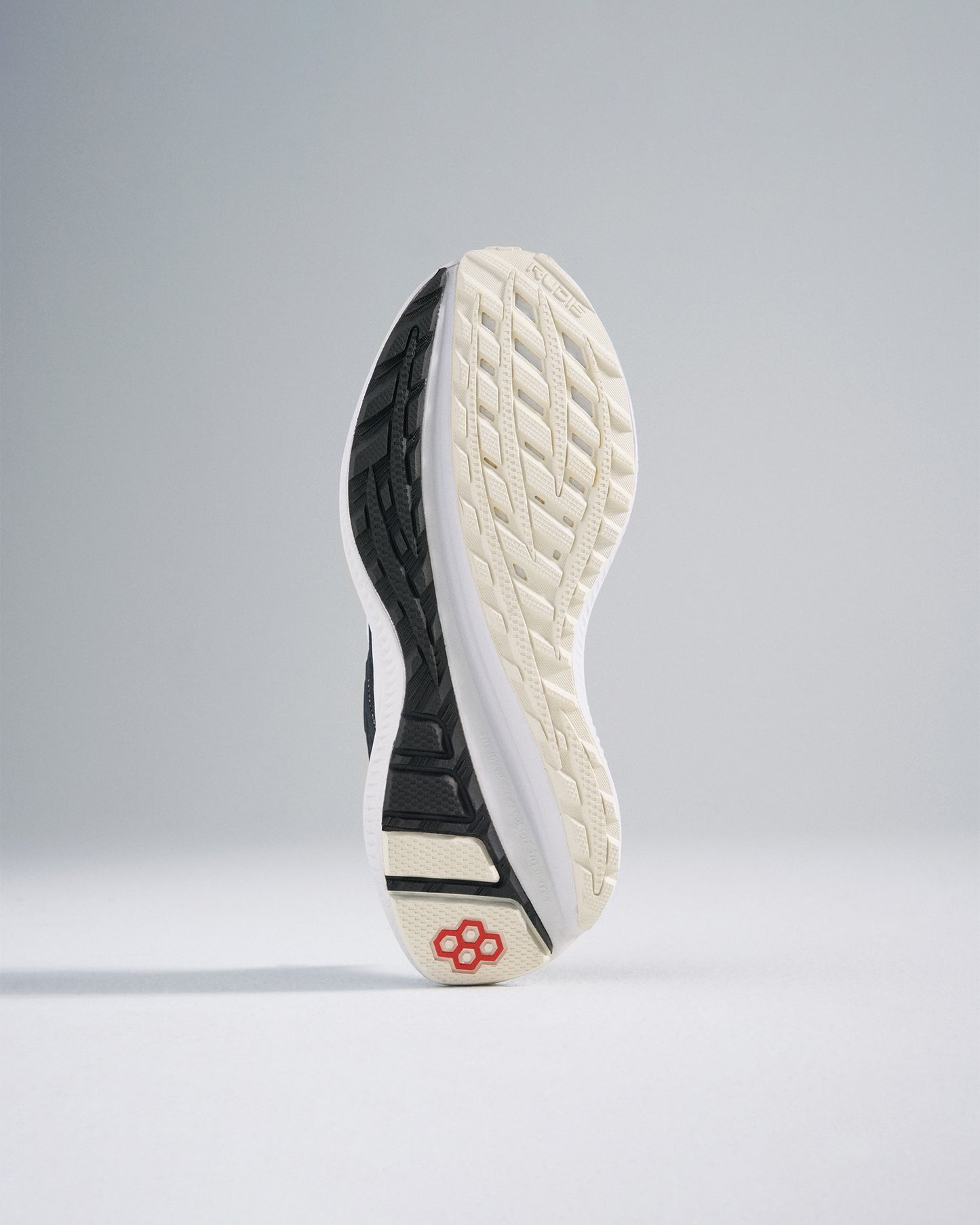 This image displays the sole of a modern athletic shoe highlighting its intricate tread design and contrasting colors