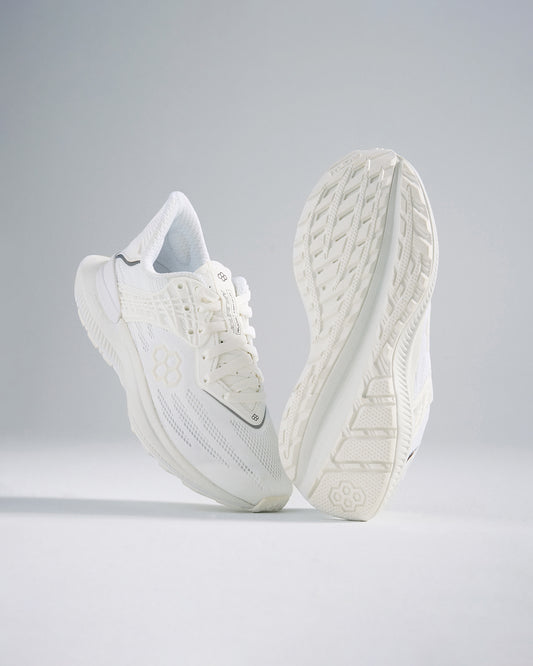 A pair of modern white athletic shoes featuring a breathable mesh upper intricate sole design and a minimalist aesthetic