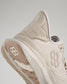 A close-up view of a modern beige athletic shoe showcasing its unique design and performance features