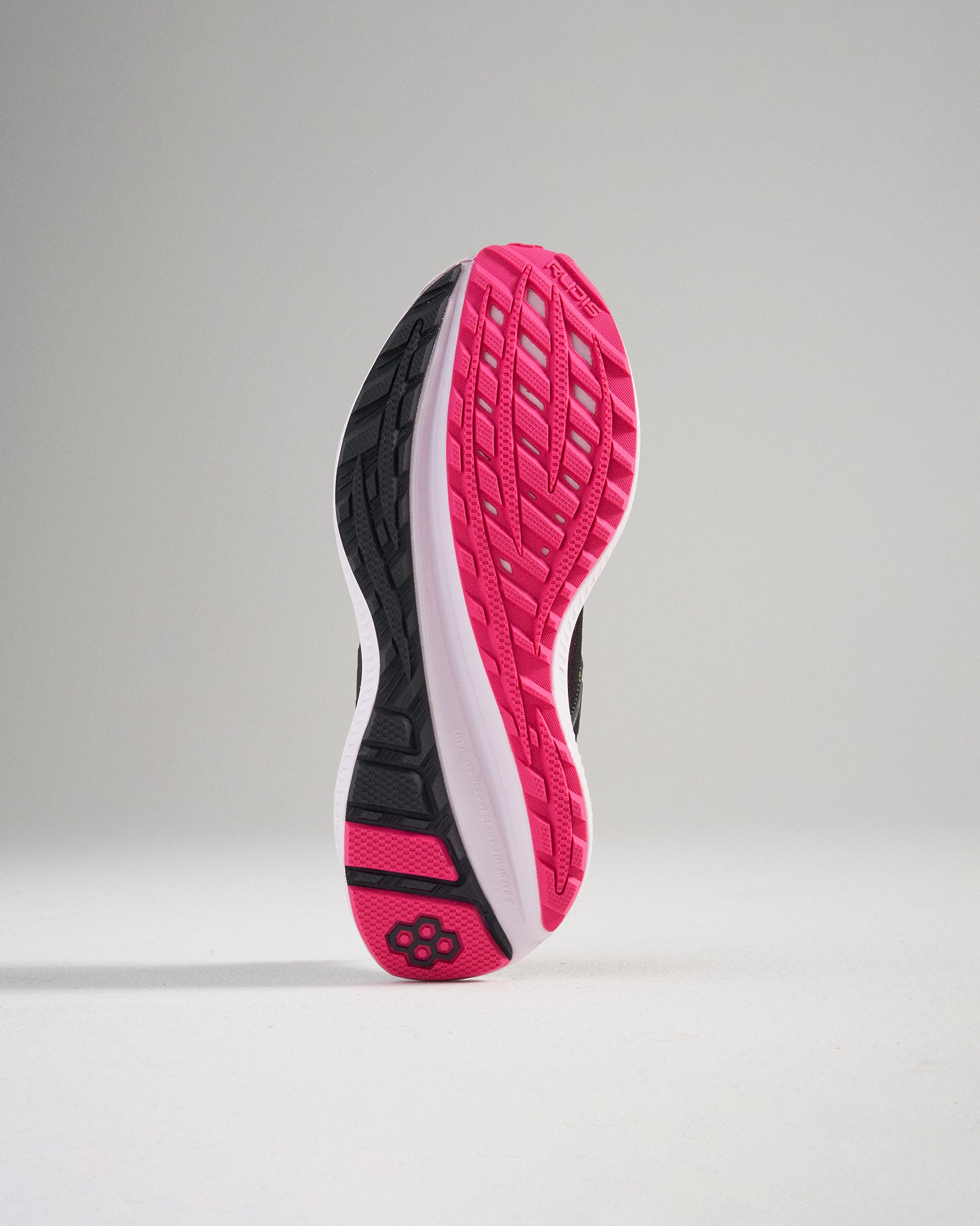 A sleek running shoe sole featuring a blend of black white and pink colors showcasing its intricate tread pattern designed for grip and performance