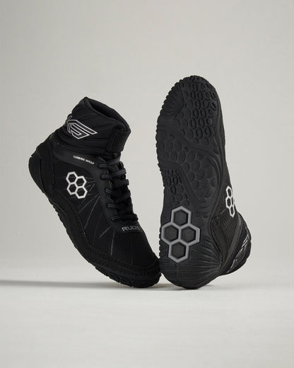 A pair of modern black athletic shoes featuring a unique design with hexagonal patterns and a textured sole for superior grip