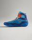 The image features a vibrant pair of blue high-top athletic shoes designed for performance with striking orange accents and innovative grip soles