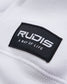 Close-up of a black tag sewn onto a white garment featuring the word RUDIS and the phrase A WAY OF LIFE