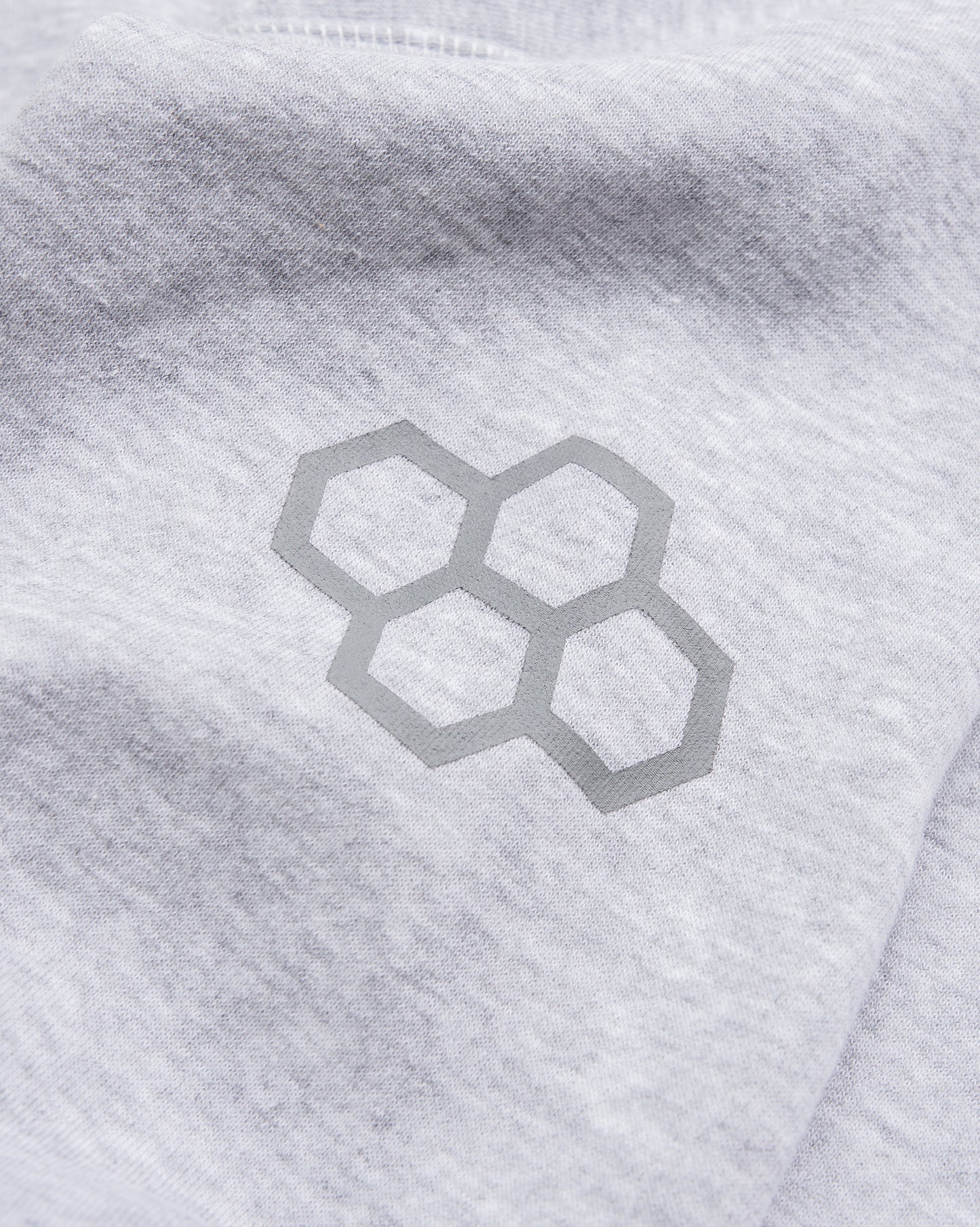 A close-up of a gray fabric featuring a geometric logo printed in a subtle silver color highlighting modern design aesthetics