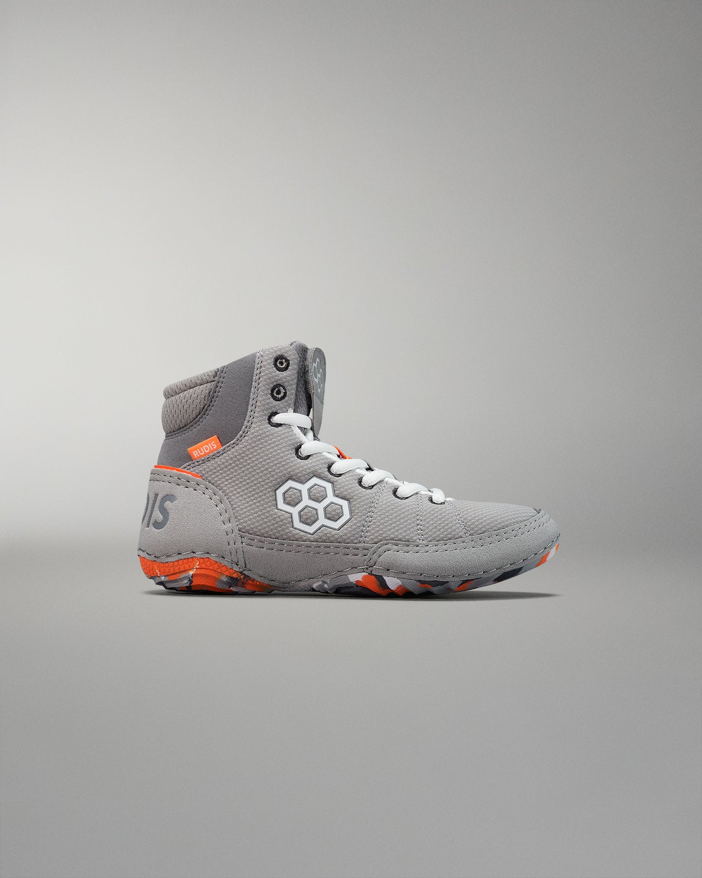 High-top athletic shoe in gray with orange accents highlights a textured surface designed for traction and support, standing out against a soft gradient background.