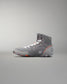 High-top athletic shoe in gray with white laces and an orange accent, designed for support and traction with a textured outsole.