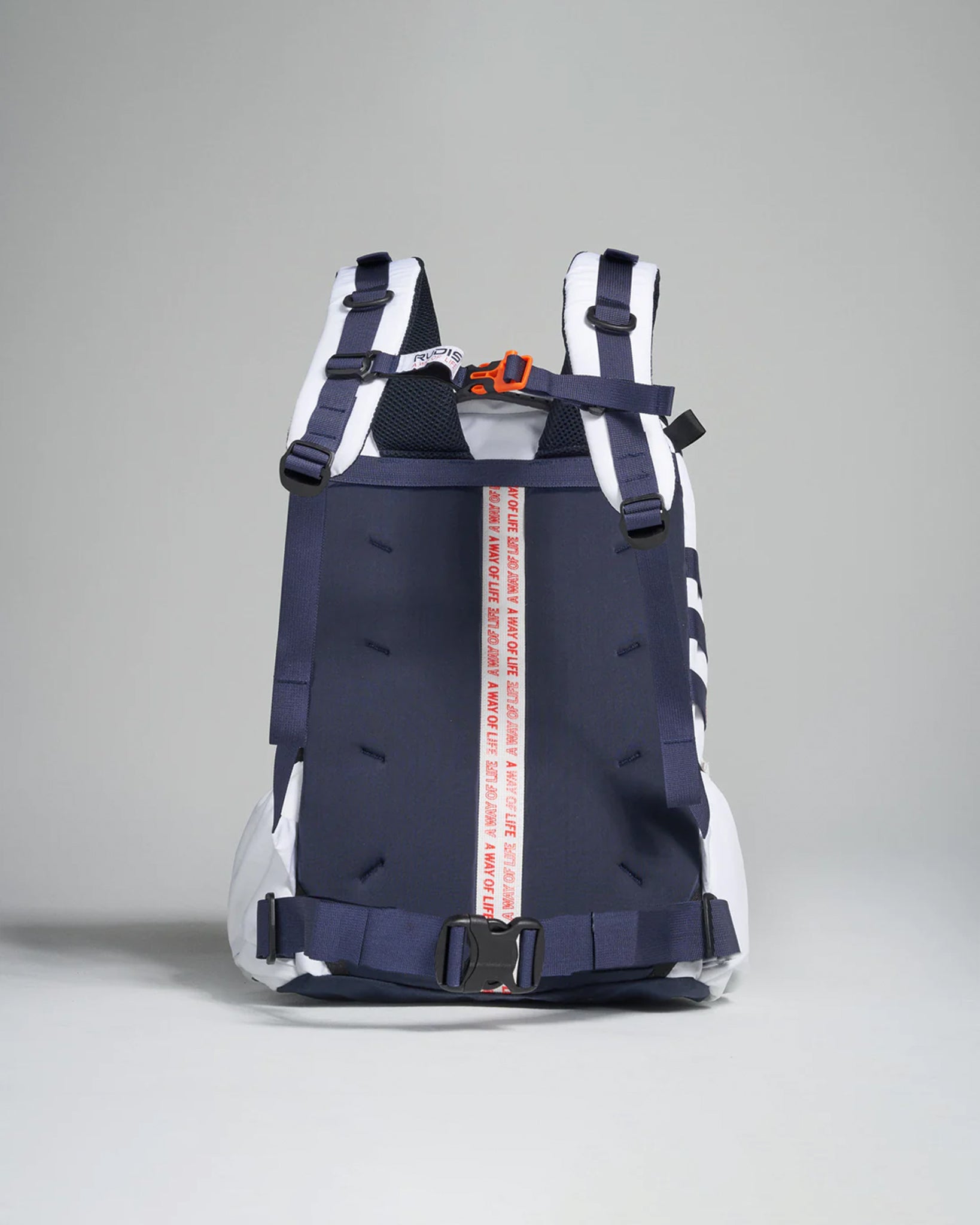 A modern navy blue and white backpack with adjustable straps a bold red and white branded strap in the center and a streamlined design suitable for both lifestyle and functional use