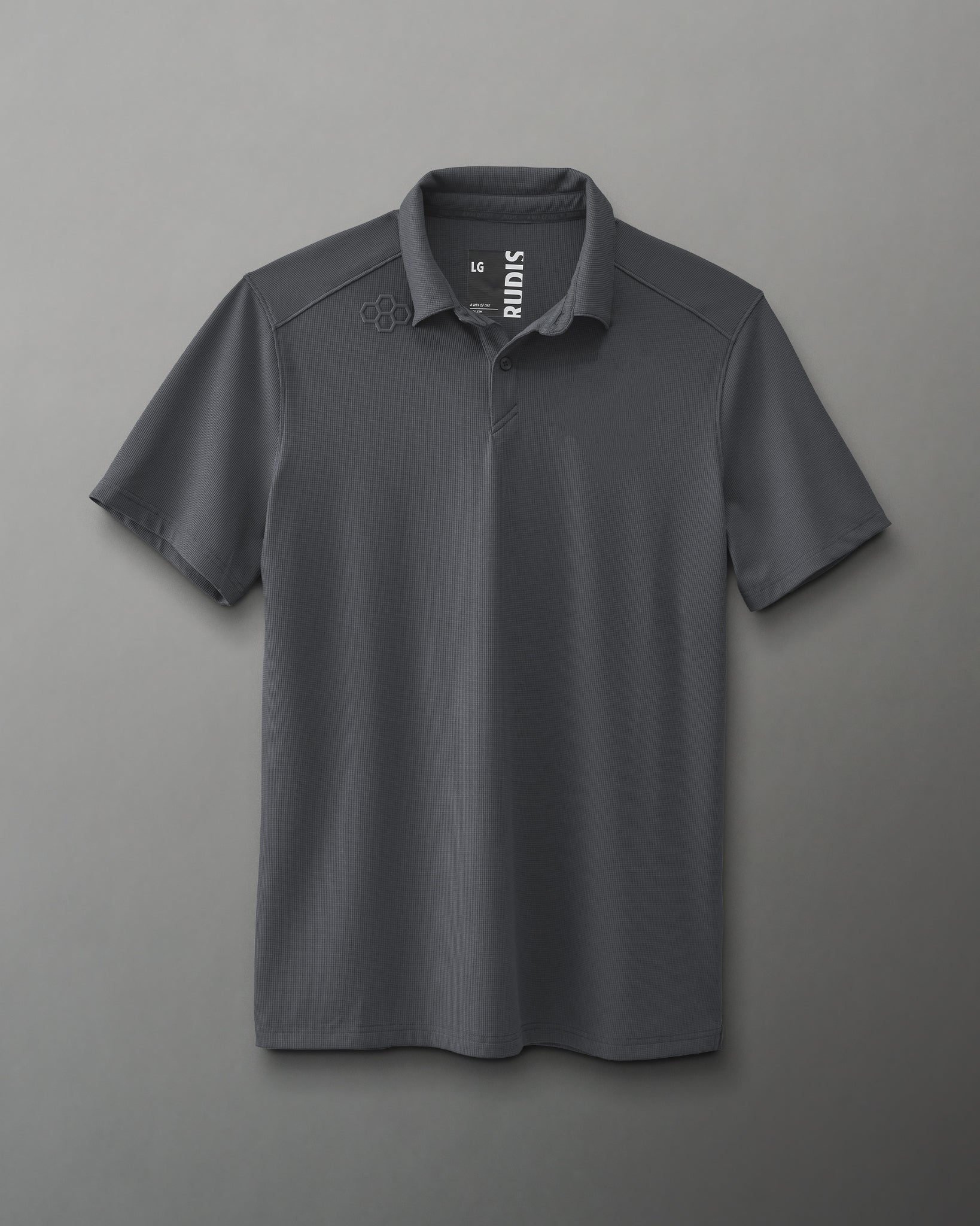 A dark gray polo shirt with a logo on the left shoulder is designed for versatility, showcasing a textured fabric against a muted gray background.