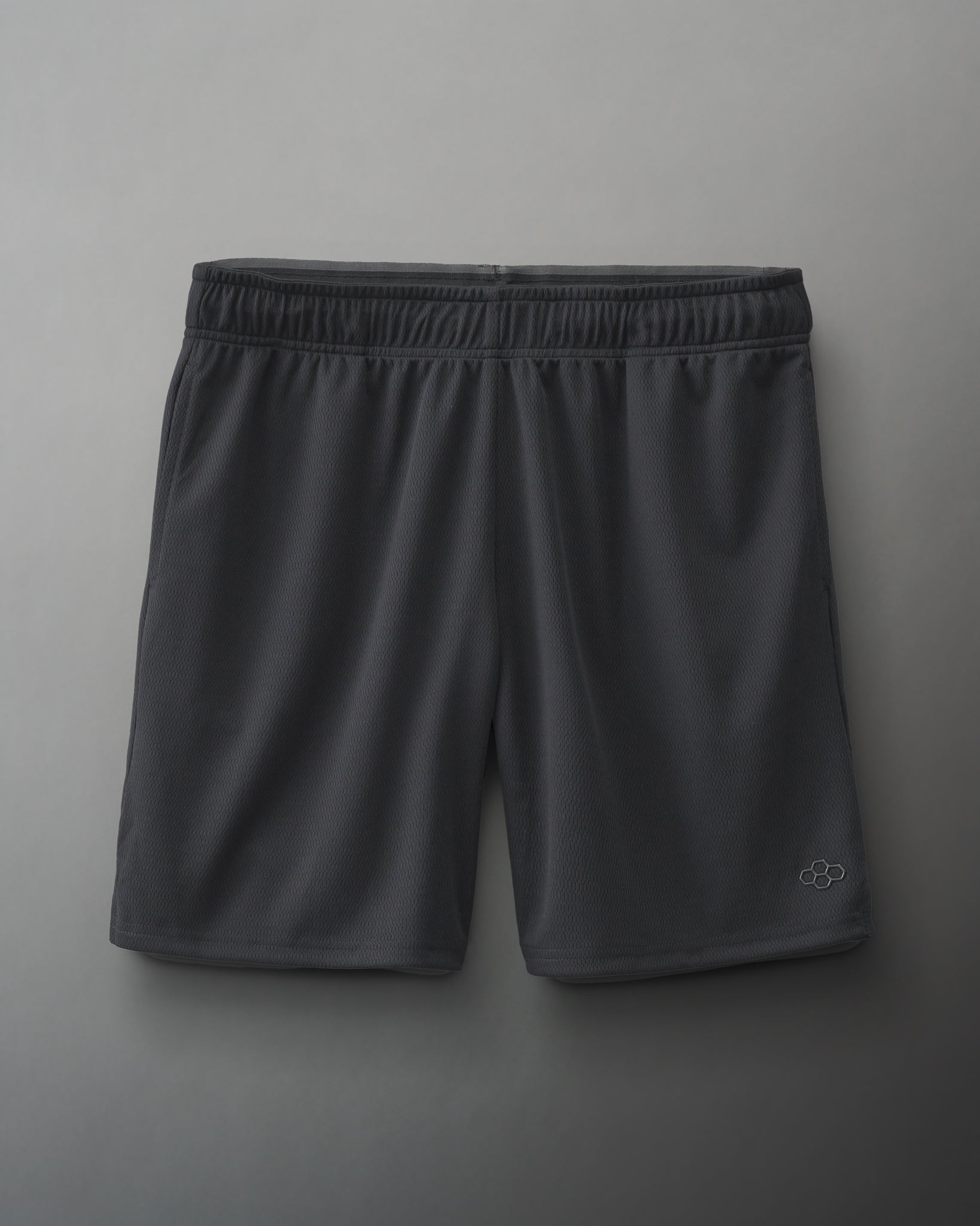 Dark gray athletic shorts with an elastic waistband and a small logo, made from lightweight mesh fabric suitable for sports.