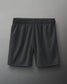 Dark gray athletic shorts with an elastic waistband and a small logo, made from lightweight mesh fabric suitable for sports.